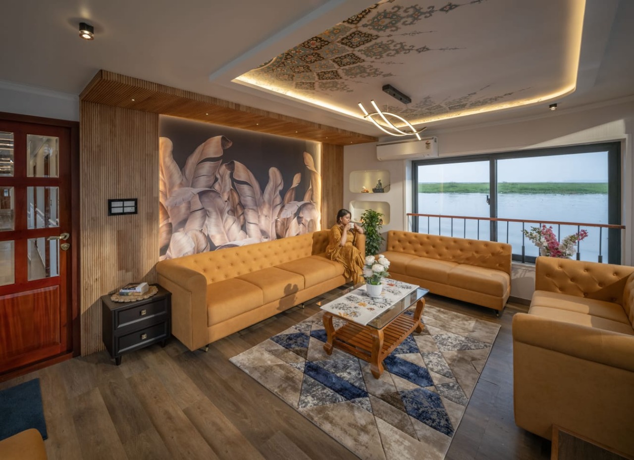 Lounge on a Nile cruise vessel in Egypt with gold sofas and a wide window looking out over the river
