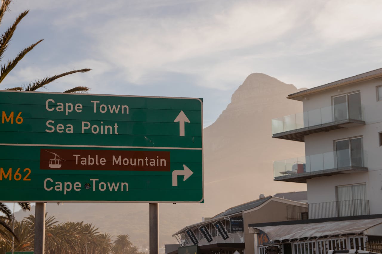 Green road sign for Cape Town, Sea Point and the Table Mountain cableway with Table Mountain in the background, South Africa