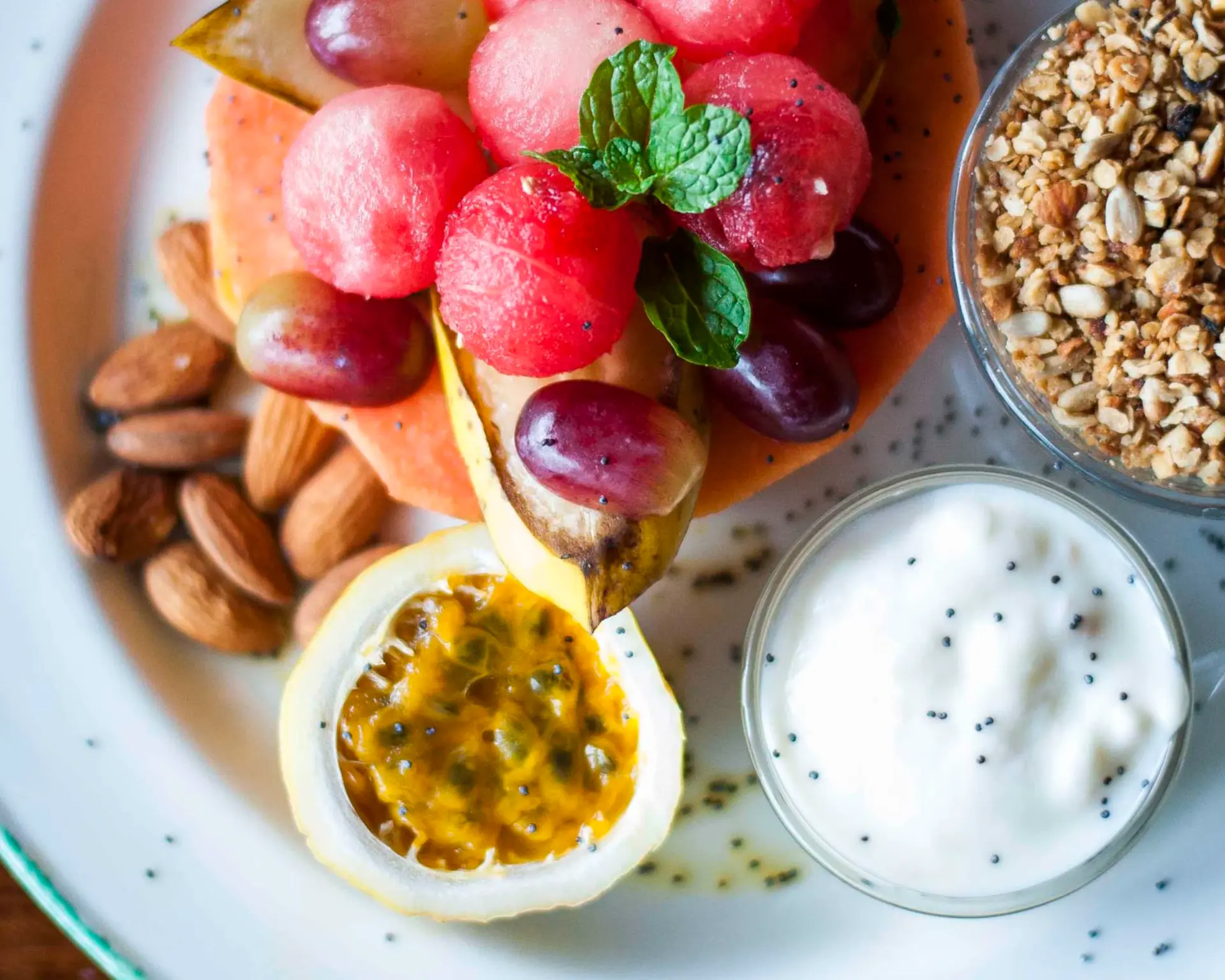 Plate of fresh papaya, grapes and passionfruit with granola and yoghurt served at Ndutu Lodge in Tanzania